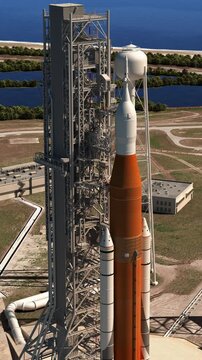 3D animation of a heavy launch vehicle standing on a launch pad before liftoff. Realistic spaceport scene with launch tower, service structures and coastal landscape.