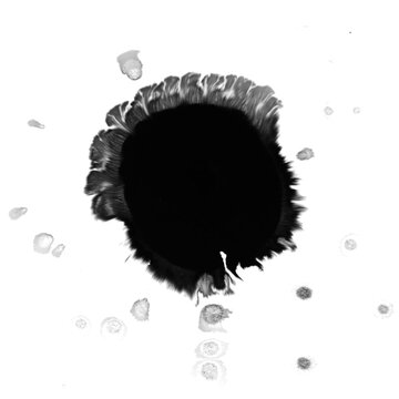 Round black ink blot with feathered brush edge and scattered spray droplets on white