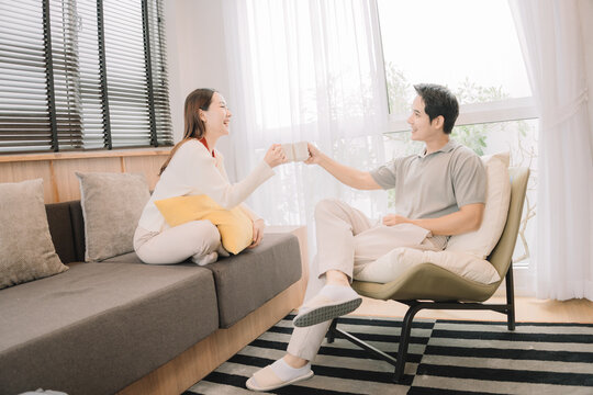 Happy Asian couple enjoying time together in their new home