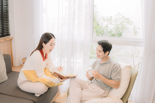 Happy Asian couple enjoying time together in their new home