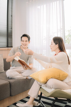 Happy Asian couple enjoying time together in their new home