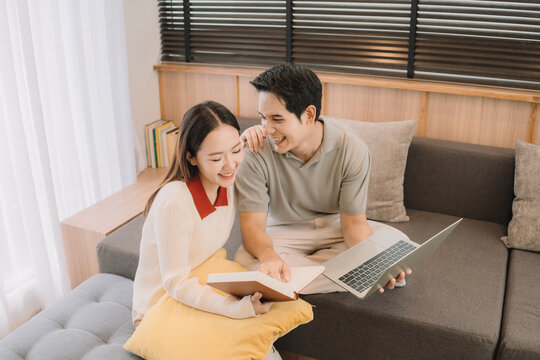 Happy Asian couple enjoying time together in their new home