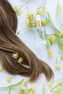 Female hair with yellow linden flowers. Closeup