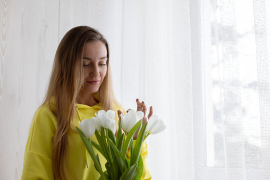 Portrait of a young woman with a bouquet of white tulips.