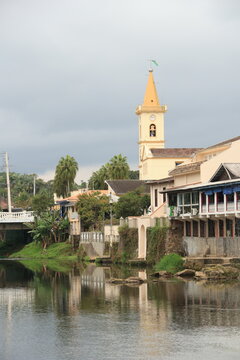 Igreja e casas da cidade de Morretes no Paran&aacute; refletidas no rio Nhundiaquara. 