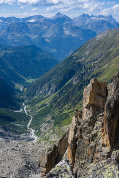 Rocky granite ridge overlooking green and lush Trient valley below in the Swiss Alps.