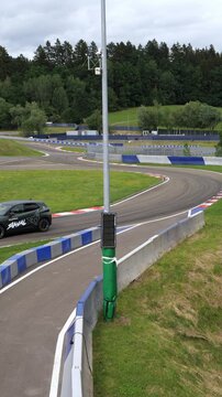 Crossover SUV cornering on an empty asphalt test track on a cloudy day