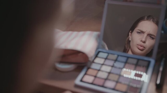 Young Woman Examining Facial Expression in Mirror