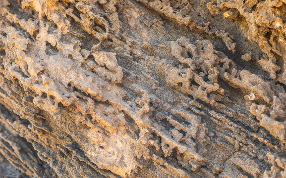 View of the weathered volcanic rock formations with intricate textures and golden-brown hues on the island of Santo Antao in Cruzinha, Ribeira Grande, Cabo Verde.