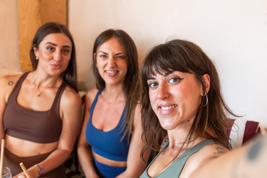 Young women friends take selfie at cafe after workout