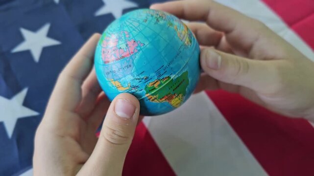 Spinning the globe while standing on a flag in a simple indoor setting