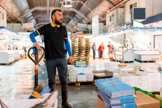 Fishmonger with fish at wholesale seafood market