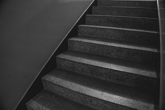 Monochrome Granite Staircase Ascending Into Darkness with Dramatic Shadows Symbolizing Progress and Upward Journey Path for Conceptual Use