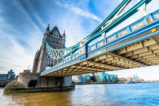 View of the iconic Tower Bridge with its blue steel structure and stone towers over the River Thames in London, England, United Kingdom.