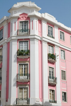 Pink and white striped apartment building facade with balconies