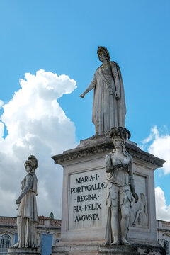 Classical statue on pedestal against blue sky with clouds