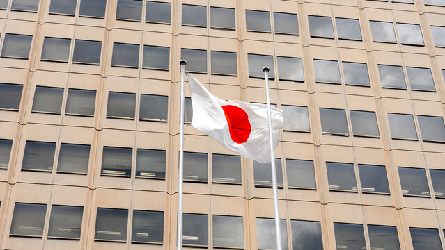 Japanese flag waving in front of an office building