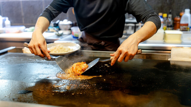 Cooking teppanyaki shrimp on a hot teppan in Kyoto