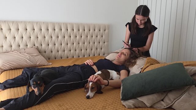 filha fazendo tran&ccedil;as no cabelo da m&atilde;e 