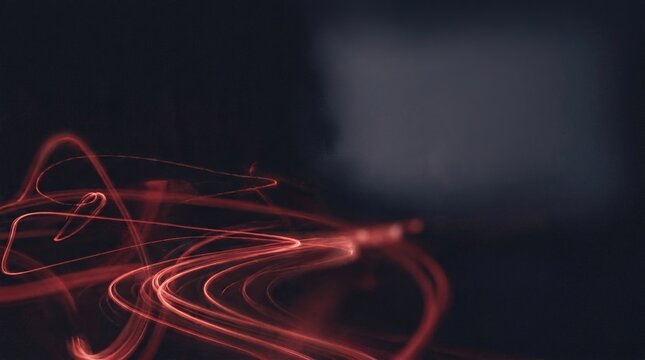 Abstract dark background with flowing red light trails with background evoking mystery