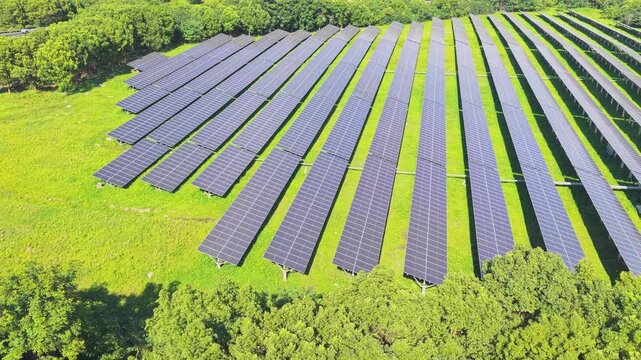 Aerial view moving over solar panels and a curved road