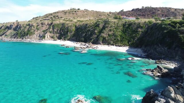 Zambrone, Calabria, Italy. Aerial drone pull-back revealing turquoise coves, secluded white beaches and rugged coastal cliffs along the Costa degli Dei.