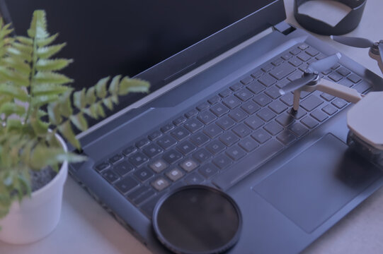 Audiovisual workspace with laptop, drone camera, filters, and memory cards. Content creation	