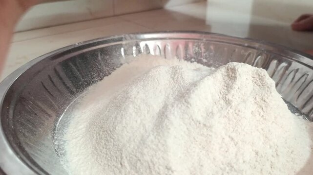Close-up of woman hands sifting wheat flour and kneading dough in traditional dish
