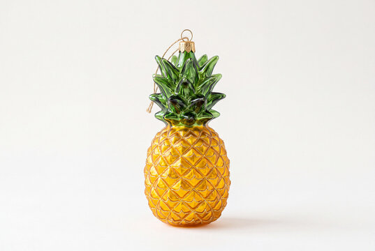 Yellow glass pineapple christmas ornament isolated on white background for holiday decoration and tabletop background for festive display and seasonal design
