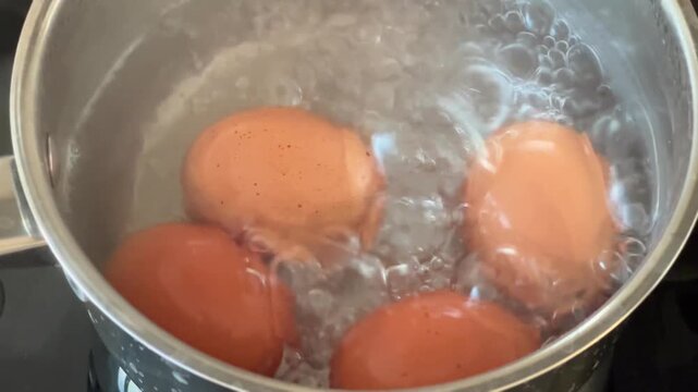 Eggs boiling and bubbling in a pot of water