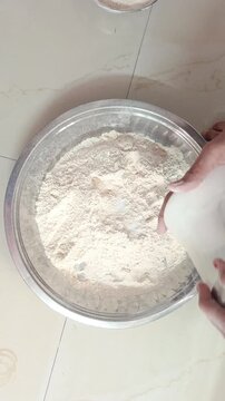 Close-up of woman hands sifting wheat flour and kneading dough in traditional dish