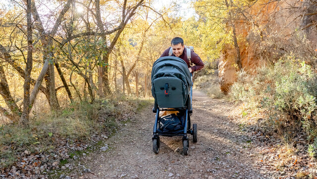 Family hiking with a stroller on a scenic trail in Spain
