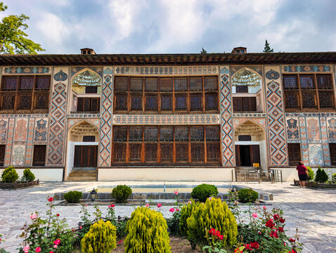 View of the historic Sheki Khans Palace featuring intricate shebeke stained-glass windows and detailed geometric wall paintings in Sheki, Shaki District, Azerbaijan.