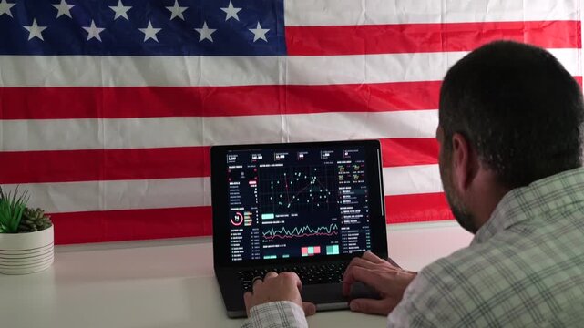 Man working on laptop displaying surveillance tracking dashboard in front of American flag, representing digital privacy and Fourth Amendment rights