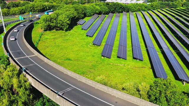 Drone gliding beside a highway and rows of solar panels