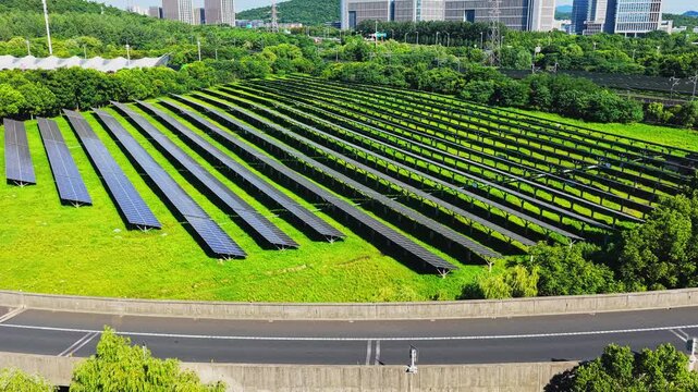 Aerial lateral view across a solar farm beside an urban road