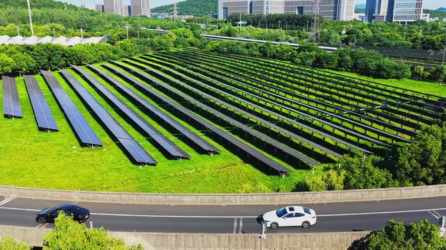 Drone tracking across solar panels with traffic on a nearby road