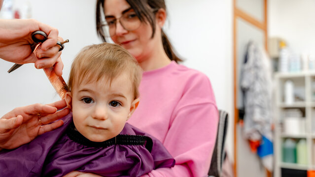 Toddler haircut with mom at hairdresser in salon
