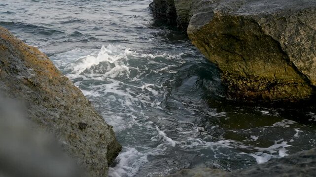 Moody Mediterranean Sea Tide Flowing Over Barnacle-Covered Ocean Rocks