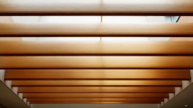 Looking up at a modern wooden slat ceiling structure with soft bright natural light wood slats architecture design beams