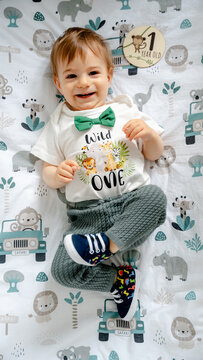 Toddler boy celebrating first birthday in safari outfit