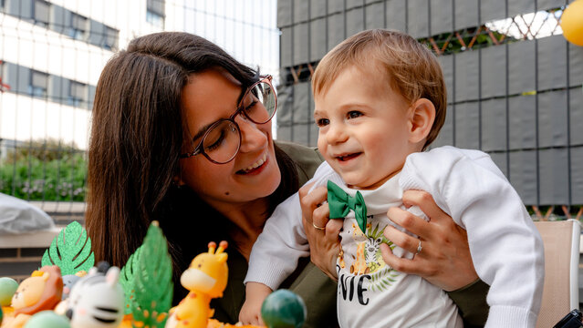 Mother with baby celebrating first birthday at outdoor party