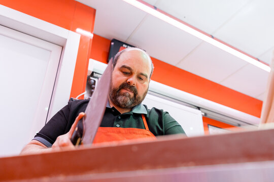 Butcher using a cleaver in a modern meat shop