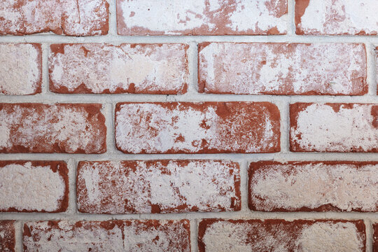 Whitewashed brick wall texture with rustic red masonry background.