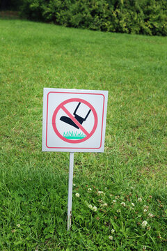 Keep off the grass warning sign on green lawn in public park