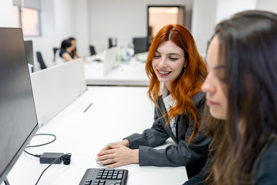 MBA students collaborate at computer workstation in classroom