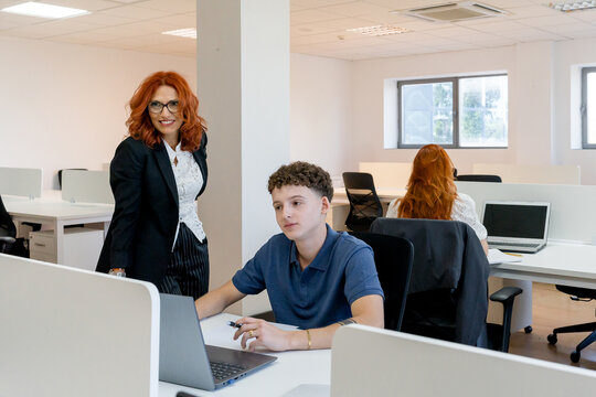 MBA students collaborate with professor in modern office