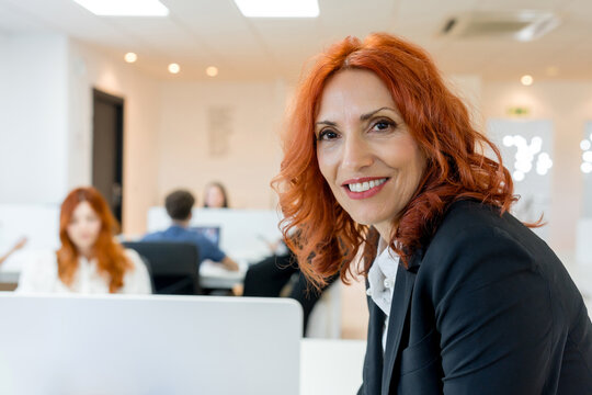 MBA mentor with students in modern business classroom