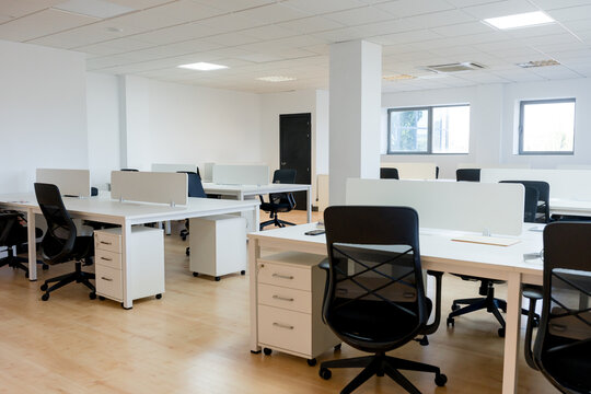 Empty open-plan office workspace with desks and chairs