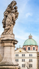Obraz premium Statue of St. Anne on Charles Bridge with Church of St. Francis of Assisi dome in Prague, Czech Republic